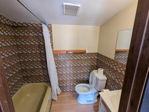 un bagno con un water, una vasca e un lavandino di Tiny Wood Cottage 10 a Wasaga Beach