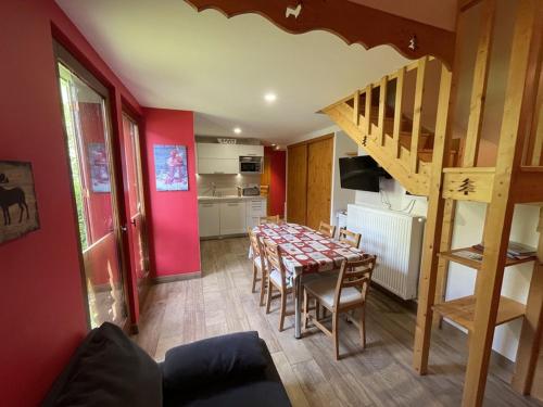 une cuisine et une salle à manger avec une table et un escalier dans l'établissement Duplex rénové 2 chambres, proche pistes, navette et gare, avec wifi et équipements complets - FR-1-787-4, à Laveissière