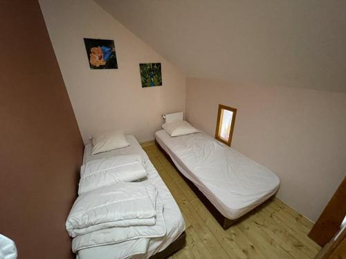 deux lits dans une chambre avec des draps blancs dans l'établissement Chalet cosy 50m² avec WiFi à 300m des pistes, 2 chambres, casier à skis, proche gare et navette - FR-1-787-12, à Laveissière
