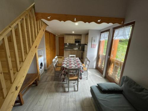 une salle à manger avec une table et des chaises et une cuisine dans l'établissement Chalet cosy 50m² avec WiFi à 300m des pistes, 2 chambres, casier à skis, proche gare et navette - FR-1-787-12, à Laveissière