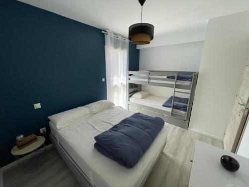 Cette petite chambre comprend un lit avec un mur bleu. dans l'établissement Charmant T3 Neuf avec Balcon, Face Télésiège et Navette Gratuite - FR-1-787-15, à Laveissière