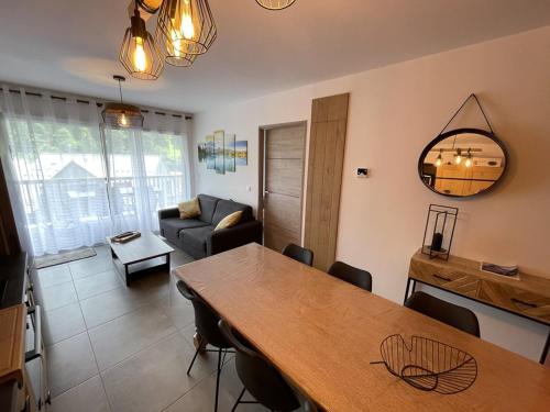 un salon avec une table et un canapé dans l'établissement Charmant T3 Neuf avec Balcon, Face Télésiège et Navette Gratuite - FR-1-787-15, à Laveissière