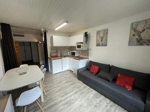 un salon avec un canapé et une table dans l'établissement Studio cosy, balcon, parking, animaux OK, proche pistes - FR-1-787-17, à Laveissière