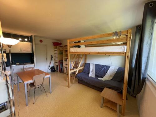 Cette chambre dispose de lits superposés, d'une table et d'un bureau. dans l'établissement Appartement cosy avec balcon, accès direct piste et parking privatif - FR-1-787-20, à Laveissière