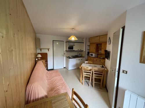 une petite chambre avec un lit et une cuisine dans l'établissement T2 cabine avec balcon, près des pistes - FR-1-787-21, à Laveissière