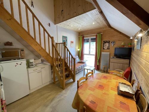 une cuisine et une salle à manger avec une table et un escalier dans l'établissement Studio-cabine-mezzanine exposé sud avec navette gratuite, casier à skis et tout confort - FR-1-787-28, à Laveissière
