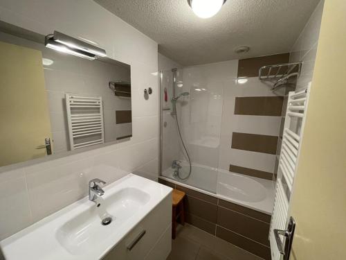 une salle de bain blanche avec un lavabo et une douche dans l'établissement Studio cosy face aux pistes avec mezzanine et navette gratuite - FR-1-787-39, à Laveissière