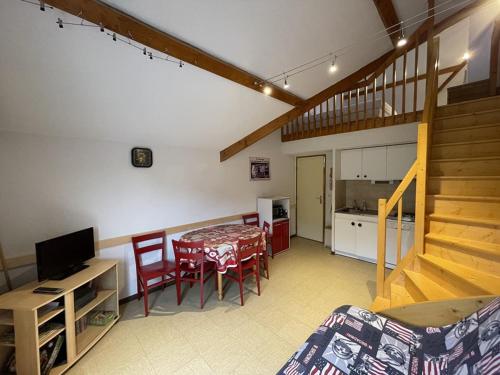 Il comprend un salon avec une table à manger et une cuisine. dans l'établissement Studio cosy face aux pistes avec mezzanine et navette gratuite - FR-1-787-39, à Laveissière