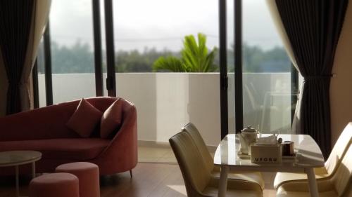 a living room with a table and a chair and a couch at Lux Resort Apartment/2BR/Private Beach/Pools in Hà My Tây (2)