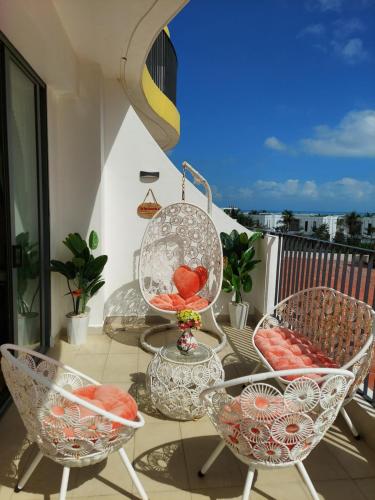 a patio with chairs and a table on a balcony at Lux Resort Apartment/2BR/Private Beach/Pools in Hà My Tây (2)