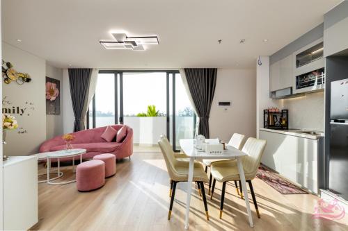 a living room with a pink couch and a table and chairs at Lux Resort Apartment/2BR/Private Beach/Pools in Hà My Tây (2)