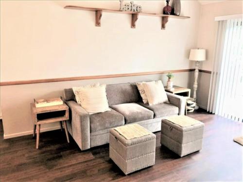 sala de estar con sofá gris y reposapiés en Village Condo condo, en Lake Arrowhead