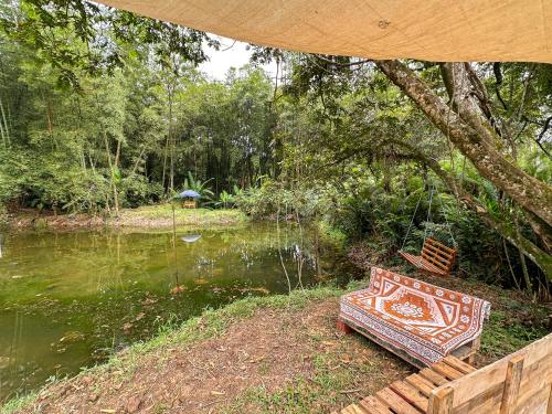 a bench sitting next to a body of water at El Nido Andino in La Mesa
