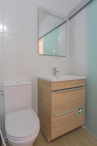 a bathroom with a white toilet and a mirror at Vila Luz Mar in Luz