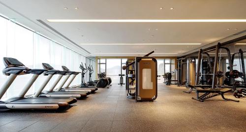 a gym with a row of treadmills and machines at Dongguan DongCheng International Hotel - Free shuttle buses for executive room guests during Canton Fair in Dongguan