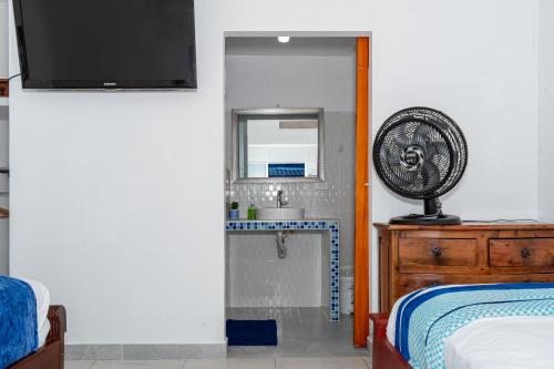 a bedroom with a bed and a fan on a dresser at Casa Hotel Victoria Real in Mariquita