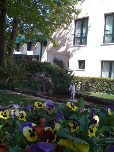 a garden with colorful flowers in front of a building at Hotel all'Orso in Biancade