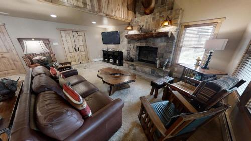 a living room with a couch and a fireplace at Antlers Riverside Lodge in Red River
