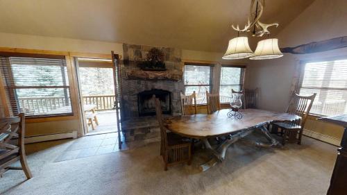 a dining room with a wooden table and a fireplace at Antlers Riverside Lodge in Red River