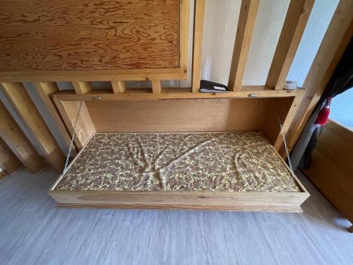 Ce lit en bois se trouve dans un dortoir doté de parquet. dans l'établissement Studio avec balcon en centre station, WiFi et animaux admis - FR-1-787-60, à Laveissière