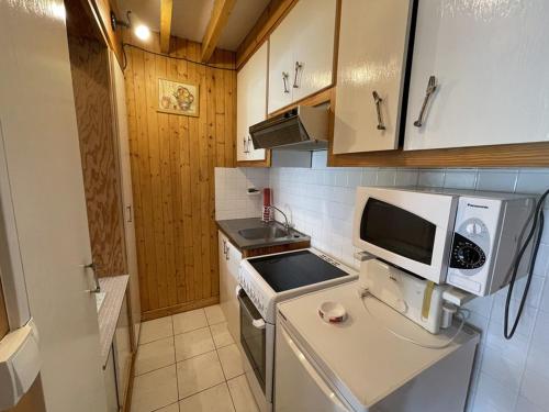 une petite cuisine avec un micro-ondes et une cuisinière dans l'établissement Studio avec balcon en centre station, WiFi et animaux admis - FR-1-787-60, à Laveissière