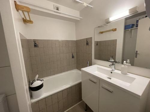 une salle de bain avec un lavabo, une baignoire et un miroir dans l'établissement Studio avec balcon au centre station, proche pistes et patinoire - FR-1-787-46, à Laveissière