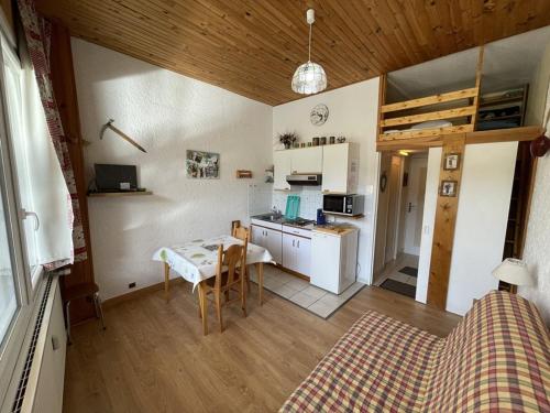 une petite cuisine avec une table et une salle à manger dans l'établissement Studio fonctionnel aux pieds des pistes avec balcon et Wi-Fi, Laveissière - FR-1-787-64, à Laveissière
