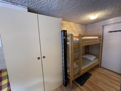 Cette petite chambre comprend des lits superposés et un placard. dans l'établissement Charmant Studio Rénové au Pied des Pistes avec Casier à Skis - FR-1-787-47, à Laveissière