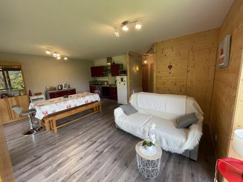 un salon avec un canapé blanc et une cuisine dans l'établissement **Appartement T3 avec Terrasse, Parking et Proche Pistes** - FR-1-787-48, à Laveissière