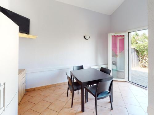 une salle à manger avec une table et des chaises noires dans l'établissement Charmante Maison avec Piscine, Tennis et Terrasse Privative - 4 Couchages, 10 min Plage - FR-1-785-4, à Vic-la-Gardiole