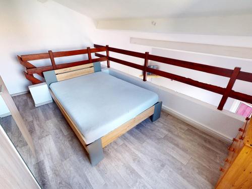 un petit lit dans une chambre avec une balustrade en bois dans l'établissement Charmante Maison avec Piscine, Tennis et Terrasse Privative - 4 Couchages, 10 min Plage - FR-1-785-4, à Vic-la-Gardiole