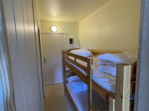 - 2 lits superposés dans une petite chambre avec une porte dans l'établissement Studio 4 pers, centre station avec WiFi, accès direct pistes et commerces - FR-1-787-66, à Laveissière