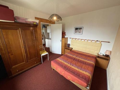 ein kleines Schlafzimmer mit einem Bett und einem Kühlschrank in der Unterkunft Charmant T2 près des pistes avec équipement bébé, casier à skis, animaux non admis - FR-1-787-68 in Laveissière