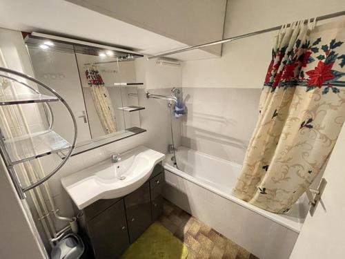ein Badezimmer mit Waschbecken, Badewanne und Dusche in der Unterkunft Charmant T2 près des pistes avec équipement bébé, casier à skis, animaux non admis - FR-1-787-68 in Laveissière