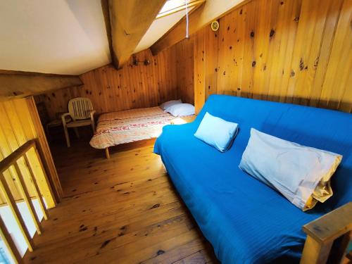 une chambre avec un lit bleu dans une pièce en bois dans l'établissement Appartement T2 Mezzanine - Proche Plage & Commerces - Parking privatif - 5 Pers - FR-1-795-49, à Fleury