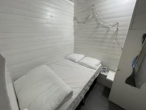 Ce petit lit se trouve dans un dortoir doté de draps blancs. dans l'établissement Studio en centre station avec balcon, WiFi - FR-1-787-71, à Laveissière