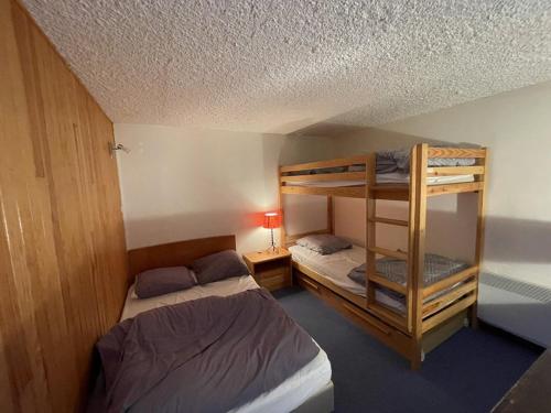 une chambre avec deux lits superposés et une lampe dans l'établissement Duplex 6/8 pers. avec balcon en plein centre, proche des pistes et commerces - FR-1-787-52, à Laveissière