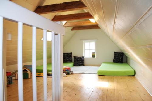 Cette chambre mansardée comprend des lits verts. dans l'établissement Välkommen, à Stralsund