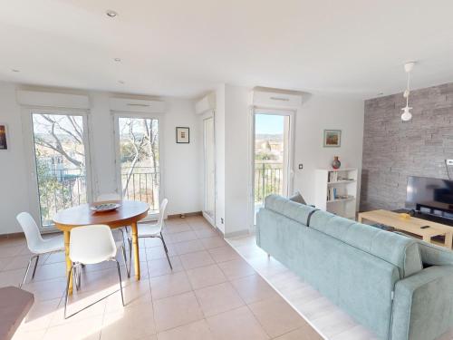 un salon avec un canapé et une table dans l'établissement Frontignan : Appartement 2 pièces avec terrasse, parking, proche plage et commerces - FR-1-785-5, à Frontignan