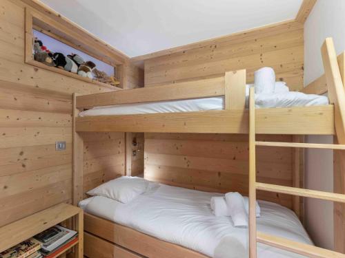 Ce lit se trouve dans un dortoir doté de 2 lits superposés et de murs en bois. dans l'établissement Appartement cosy à Méribel, proche des remontées et commerces, 4 pers, balcon, WIFI inclus - FR-1-565-109, à Les Allues
