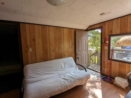 una camera da letto con un letto in una stanza con pareti in legno di Tiny Wood Cottage 12 a Wasaga Beach