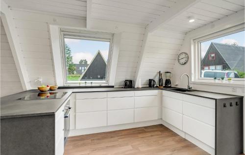 a kitchen with white cabinets and a large window at 2 Bedroom Cozy Home In Farsø in Farsø