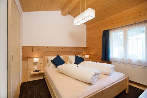 a bedroom with a large white bed with a window at Boutique-Hotel Vincenz in Brigels