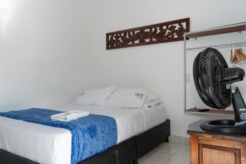 a bedroom with a bed with a fan on the wall at Casa Hotel Victoria Real in Mariquita