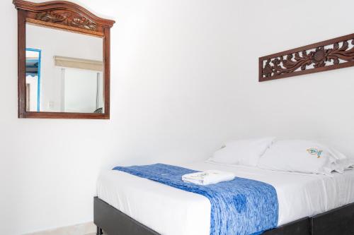 a bedroom with a bed and a mirror at Casa Hotel Victoria Real in Mariquita