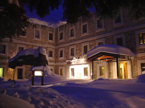 a building covered in snow at night at Hotel Santa Cristina Petit Spa in Canfranc-Estación