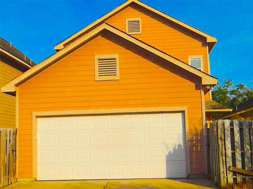 a large orange house with a white garage at Spacious 5bed Houston Retreat Home in Houston