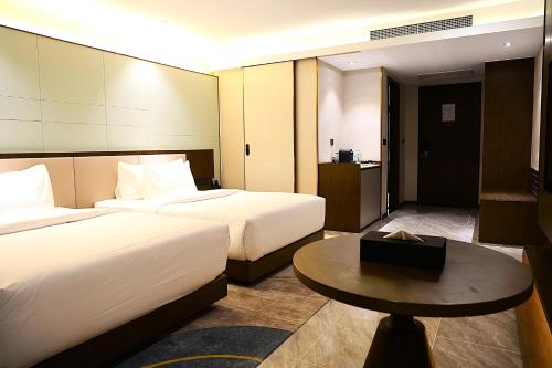 a hotel room with two beds and a table at Castle Bayview Resort & Spa in Kampot