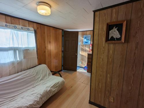 una piccola camera da letto con un letto e una finestra di Tiny Wood Cottage 15 a Wasaga Beach