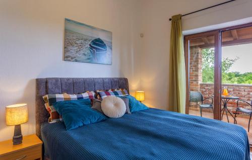 a bedroom with a blue bed and a balcony at 3 Bedroom Gorgeous Home In Cabrunici in Čabrunići